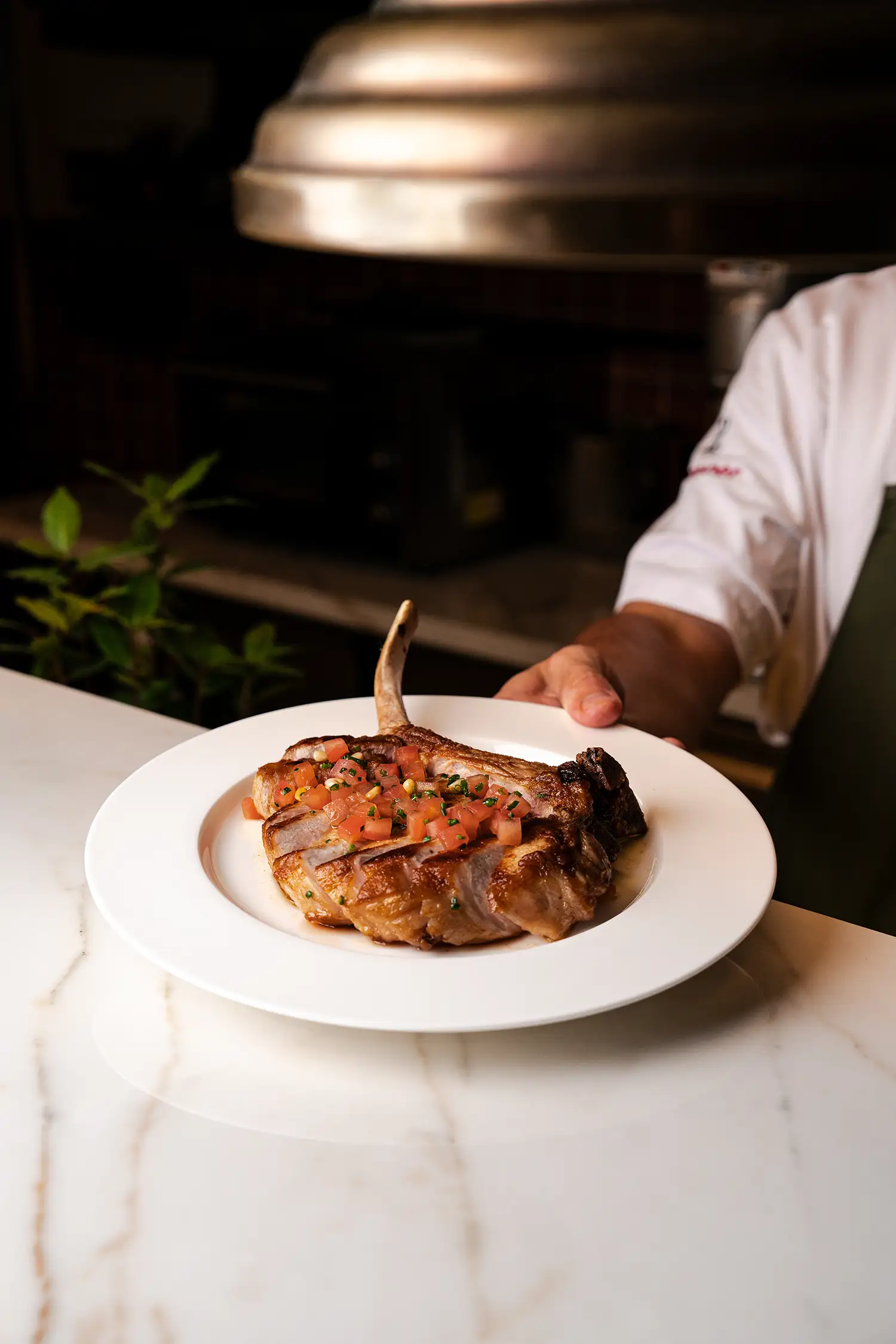 Koch reicht Fleischgericht über die Theke